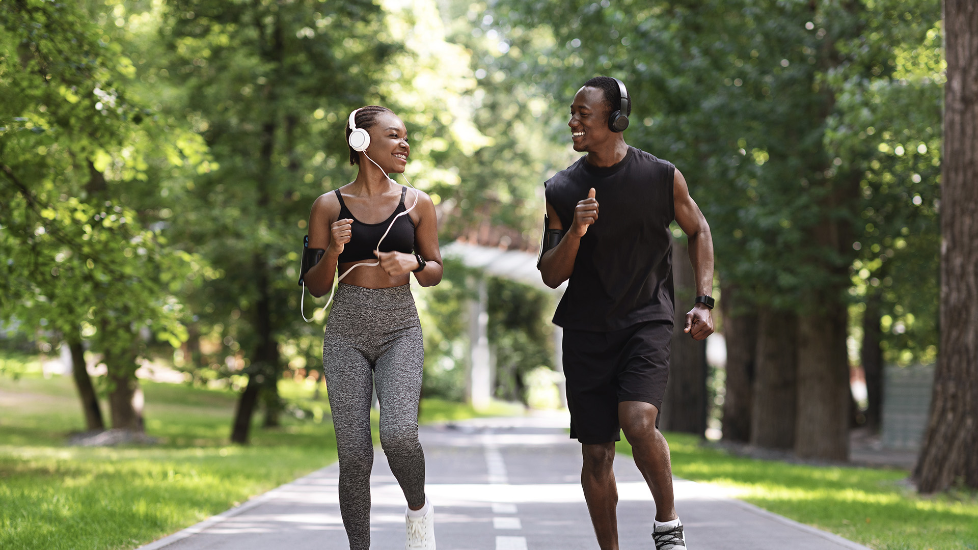 A couple jogging outdoors on a nice day.